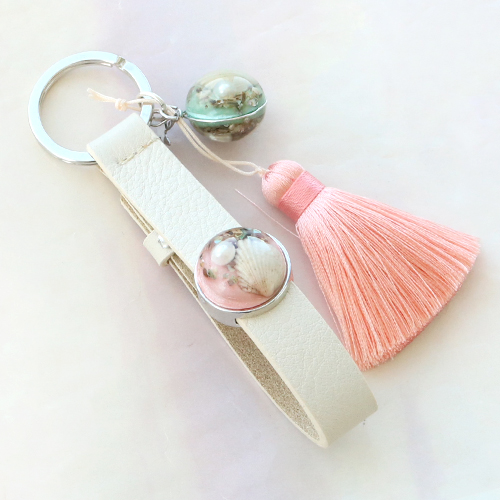 Armbanden en sleutelhangers met bedels en cabochons met echte bloemen en schelpen